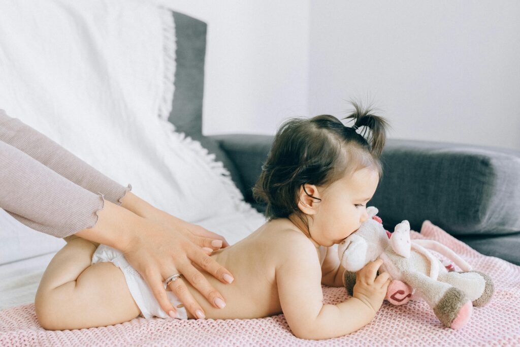 pexels-photo-5889962-5889962 A serene moment of a baby receiving a gentle massage while holding a plush toy, epitomizing peace and comfort.